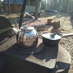 Kahvipannu ja kattila grillin hellaosan päällä ulkona