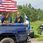 lonkeroa Lava-auton lavalla juodaan lonkeroa. Amerikan ja Suomen liput liehuvat