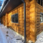 Hirsitalon kulma. Ikkunoissa tumman harmaat puitteet