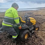 Mies nostaa puutarhatraktoria liejusta