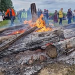 Suurista puunrungoista kasattu matala kokko palaa